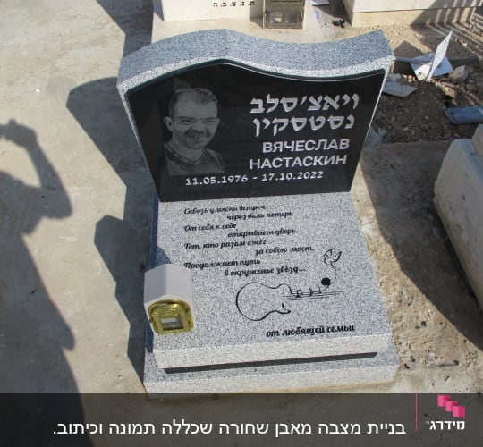 מצבה עם כיתוב בעברית ורוסית ותמונה של אדם